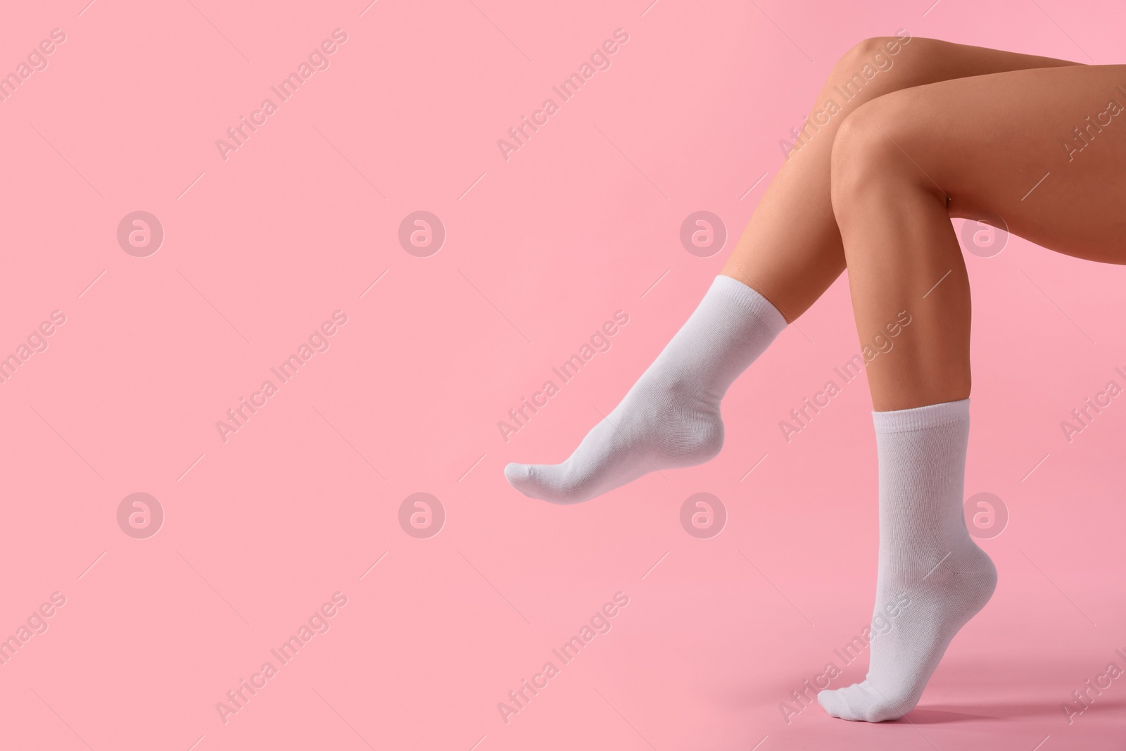 Photo of Woman in stylish white socks on pink background, closeup. Space for text