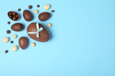 Photo of Flat lay composition with chocolate Easter eggs and space for text on color background