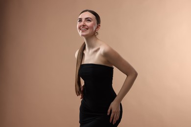 Photo of Portrait of beautiful young woman on beige background