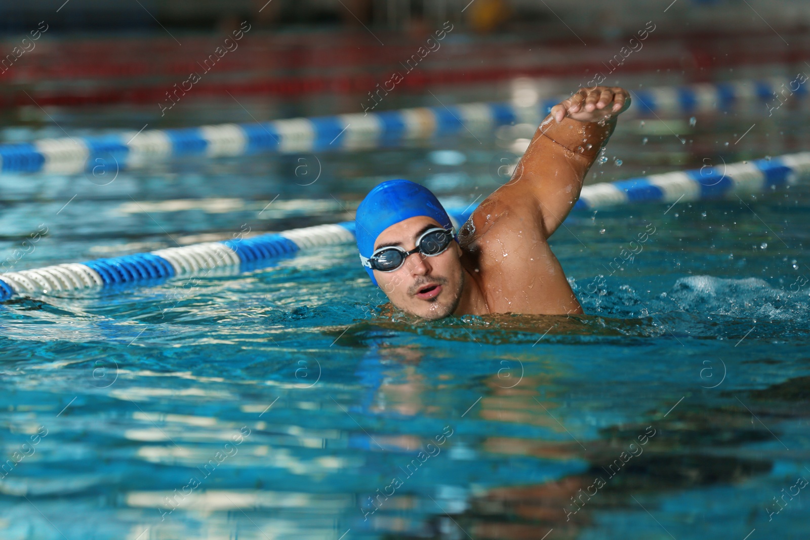 Photo of Young athletic man swimming in pool indoors
