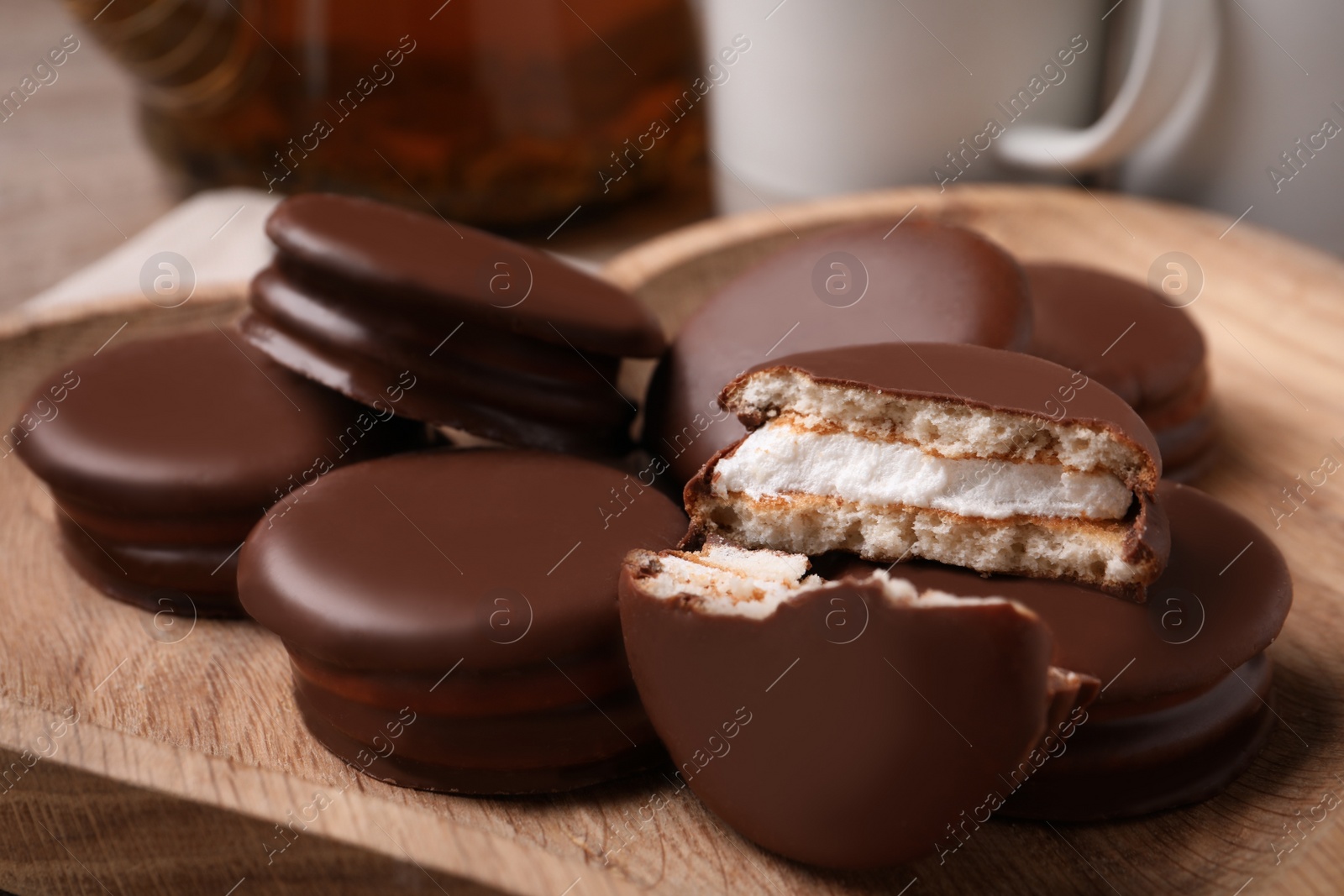 Photo of Tasty choco pies on wooden plate, closeup view