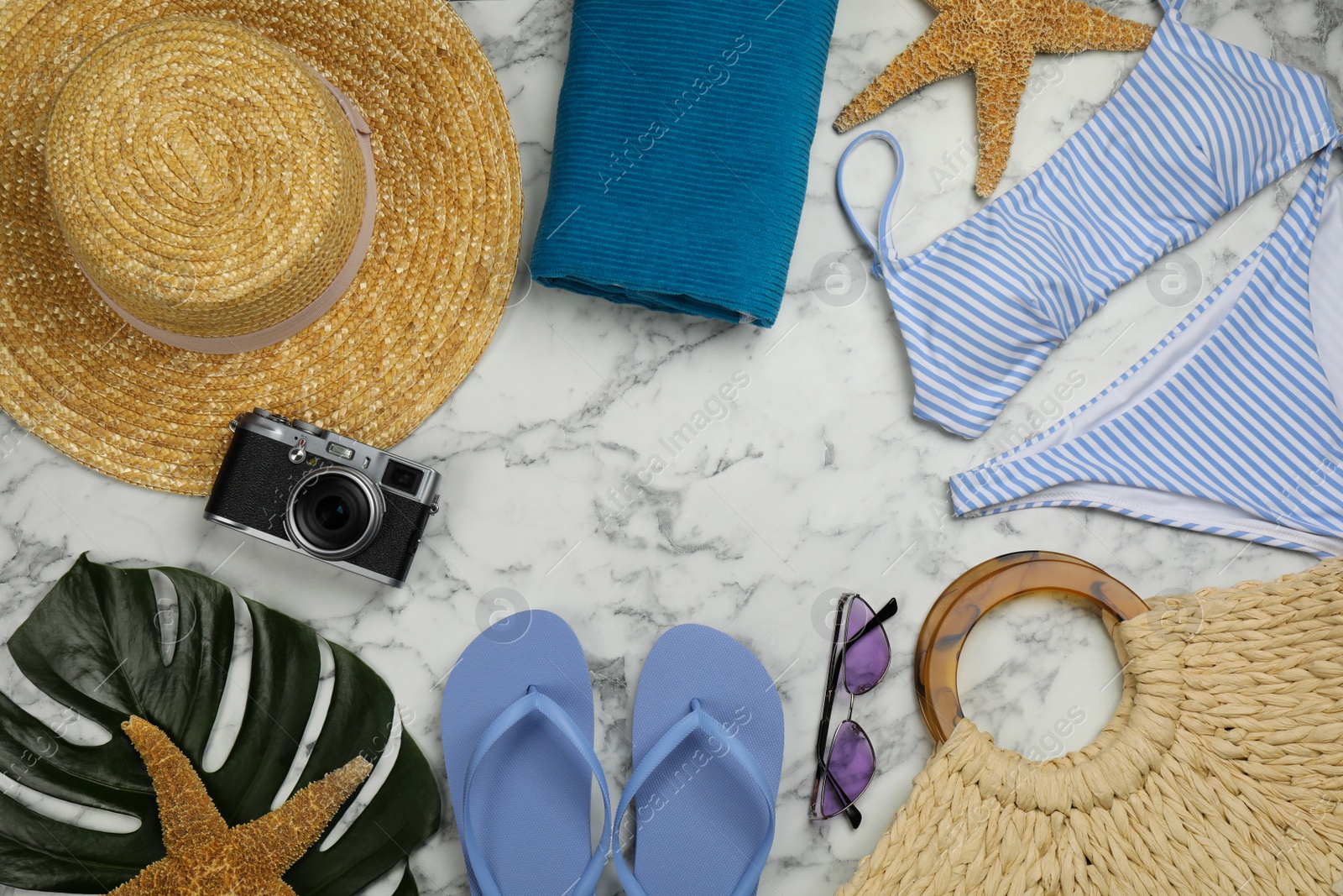 Photo of Frame of beach objects on white marble background, flat lay. Space for text