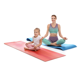 Young woman and her daughter doing exercise isolated on white. Home fitness