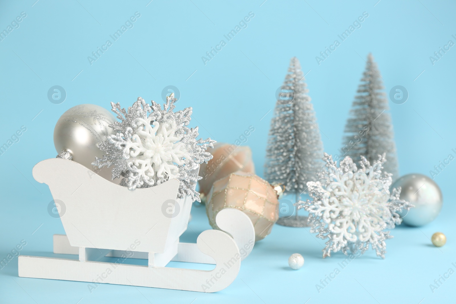 Photo of Beautiful Christmas composition with miniature sleigh on light blue background