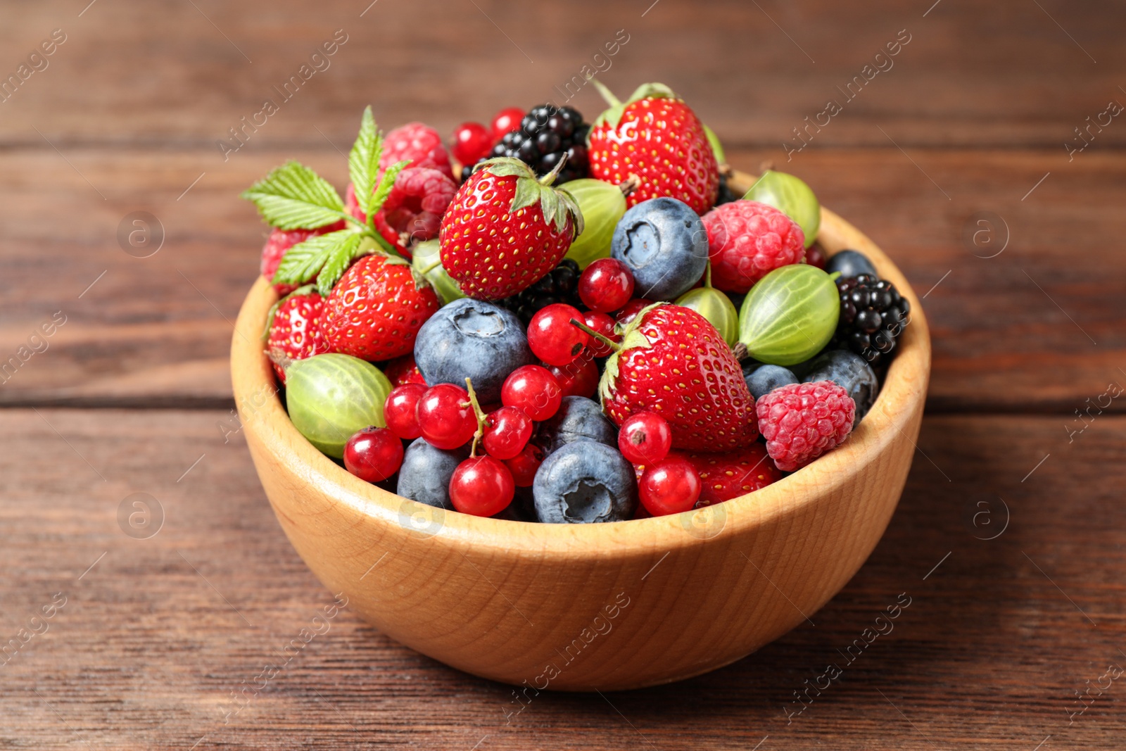 Photo of Mix of ripe berries on wooden table