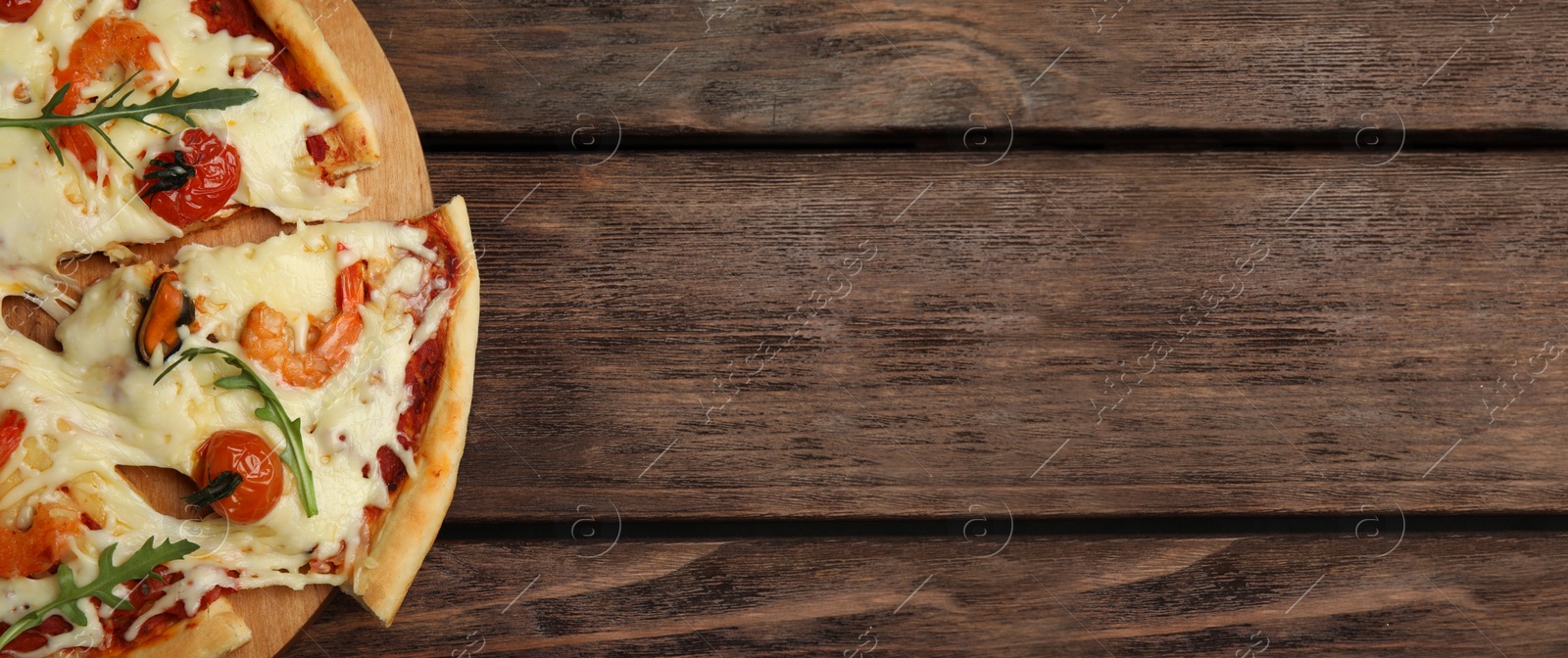 Image of Top view of hot delicious pizza on wooden table, space for text. Banner design 