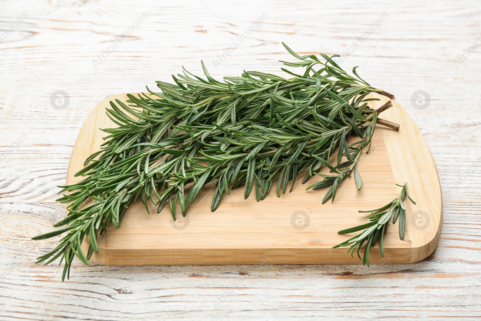 Photo of Bunch of fresh rosemary on white wooden table