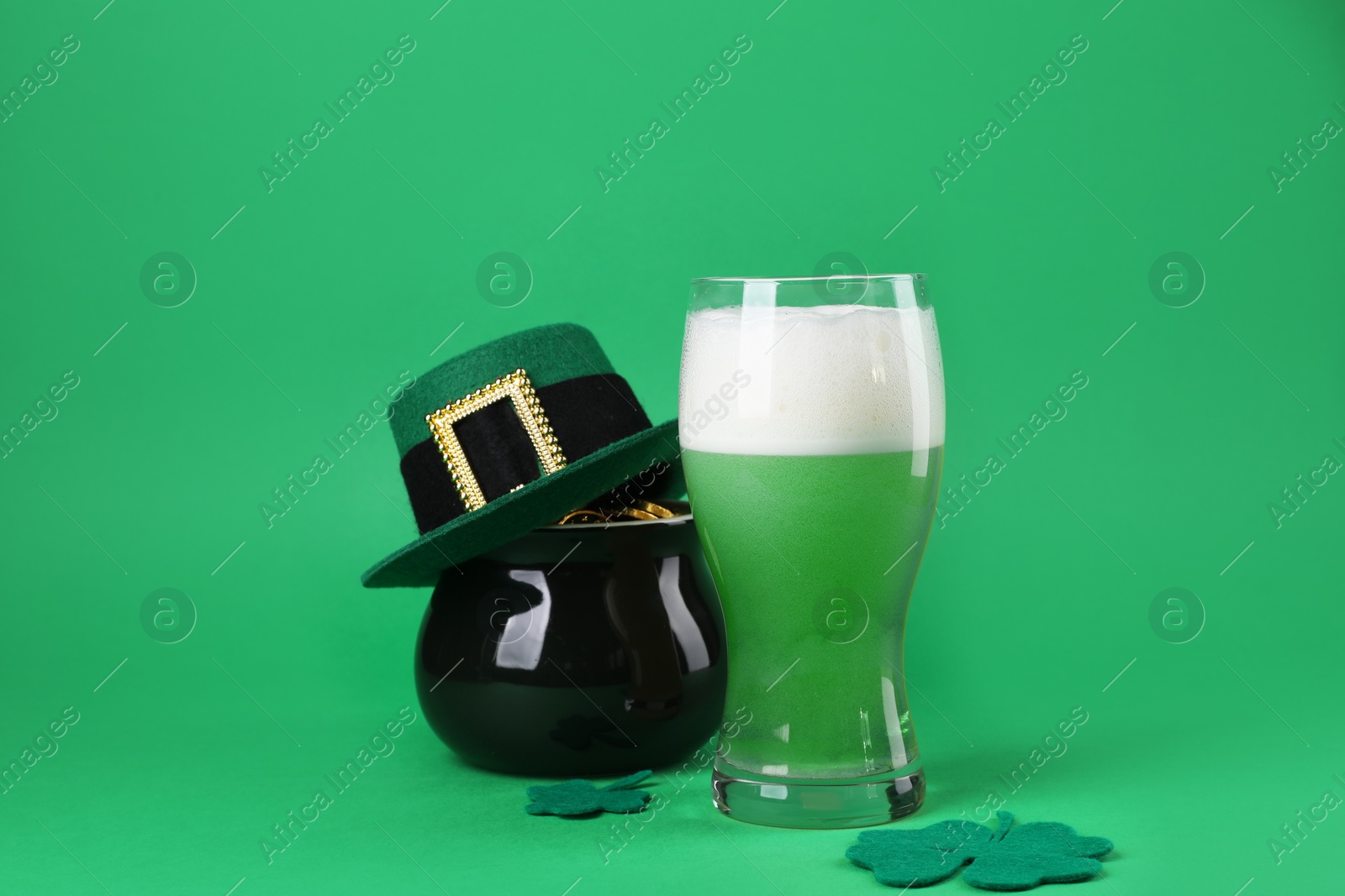 Photo of St. Patrick's day party. Green beer, leprechaun hat, pot of gold and decorative clover leaves on green background