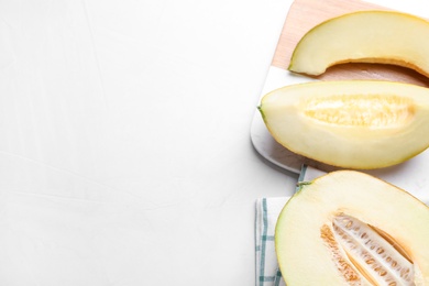 Photo of Pieces of delicious honeydew melon on white table, flat lay. Space for text