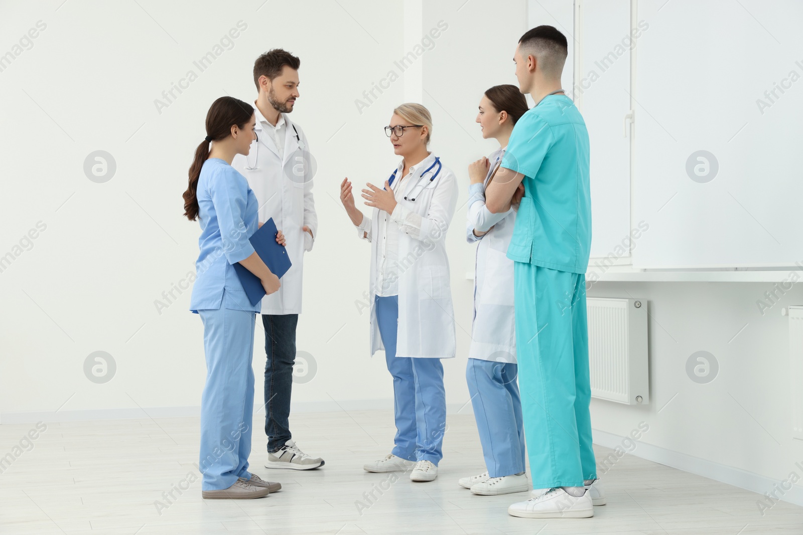 Photo of Medical doctors in uniforms having discussion in clinic