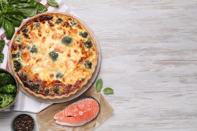 Photo of Delicious homemade quiche and ingredients on wooden table, flat lay. Space for text