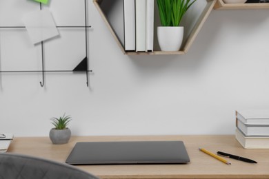 Home workspace. Laptop and stationery on wooden desk indoors