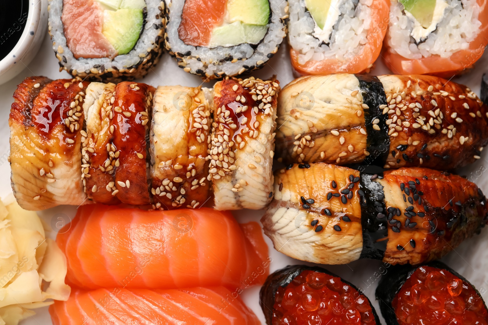 Photo of Set of delicious sushi rolls on board, top view