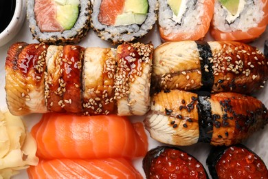 Set of delicious sushi rolls on board, top view