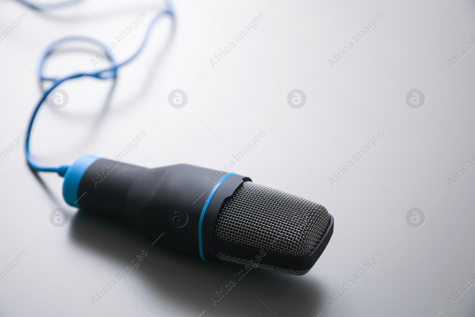 Photo of Microphone on light grey background. Journalist's work