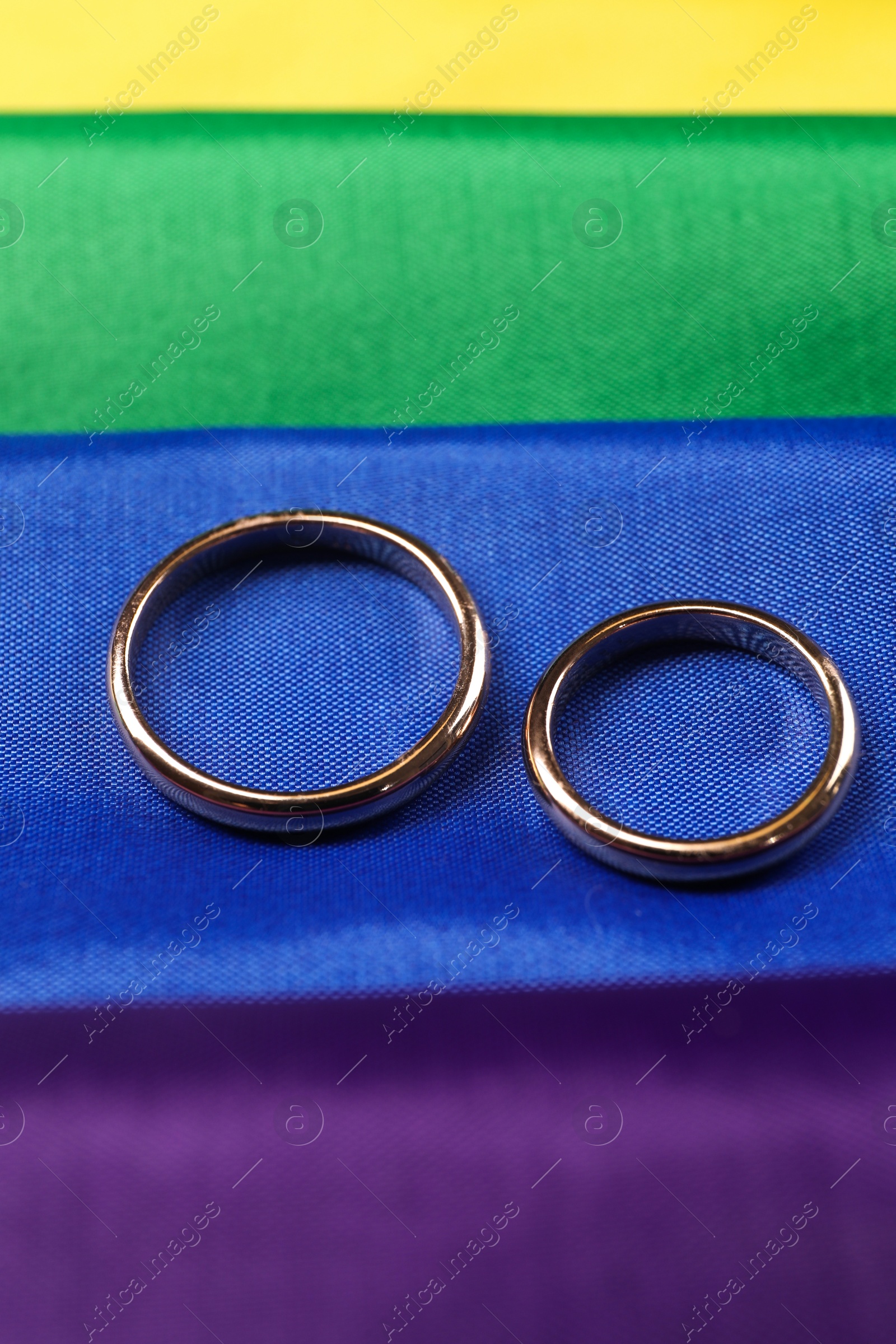 Photo of Wedding rings on rainbow LGBT flag, closeup