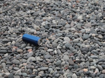 Photo of Can thrown out on pebble coast. Space for text