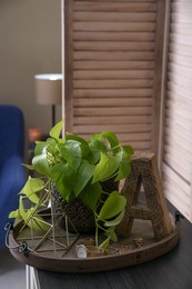 Stylish tray with different interior elements on wooden table in room