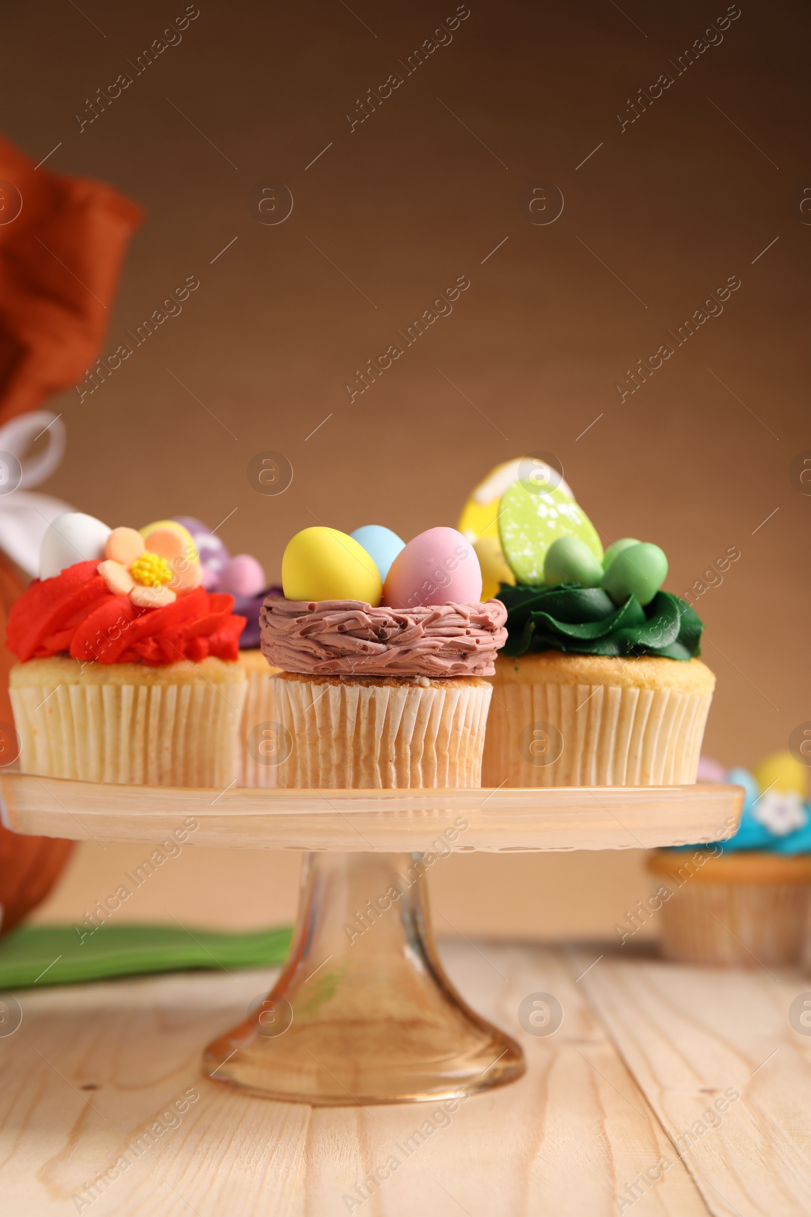 Photo of Tasty cupcakes with Easter decor on wooden table