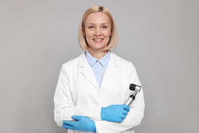 Happy dermatologist with dermatoscope on grey background