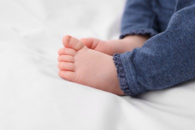 Photo of Newborn baby lying on white blanket, closeup