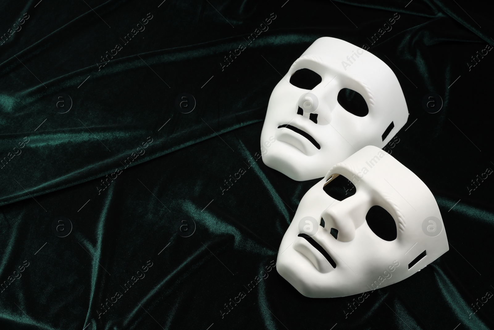 Photo of Theater arts. White masks on green fabric, above view. Space for text