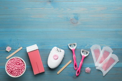 Photo of Set of epilation products on light blue wooden table, flat lay. Space for text