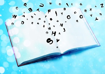 Image of Letters flying out from open book on light blue background, above view. Bokeh effect