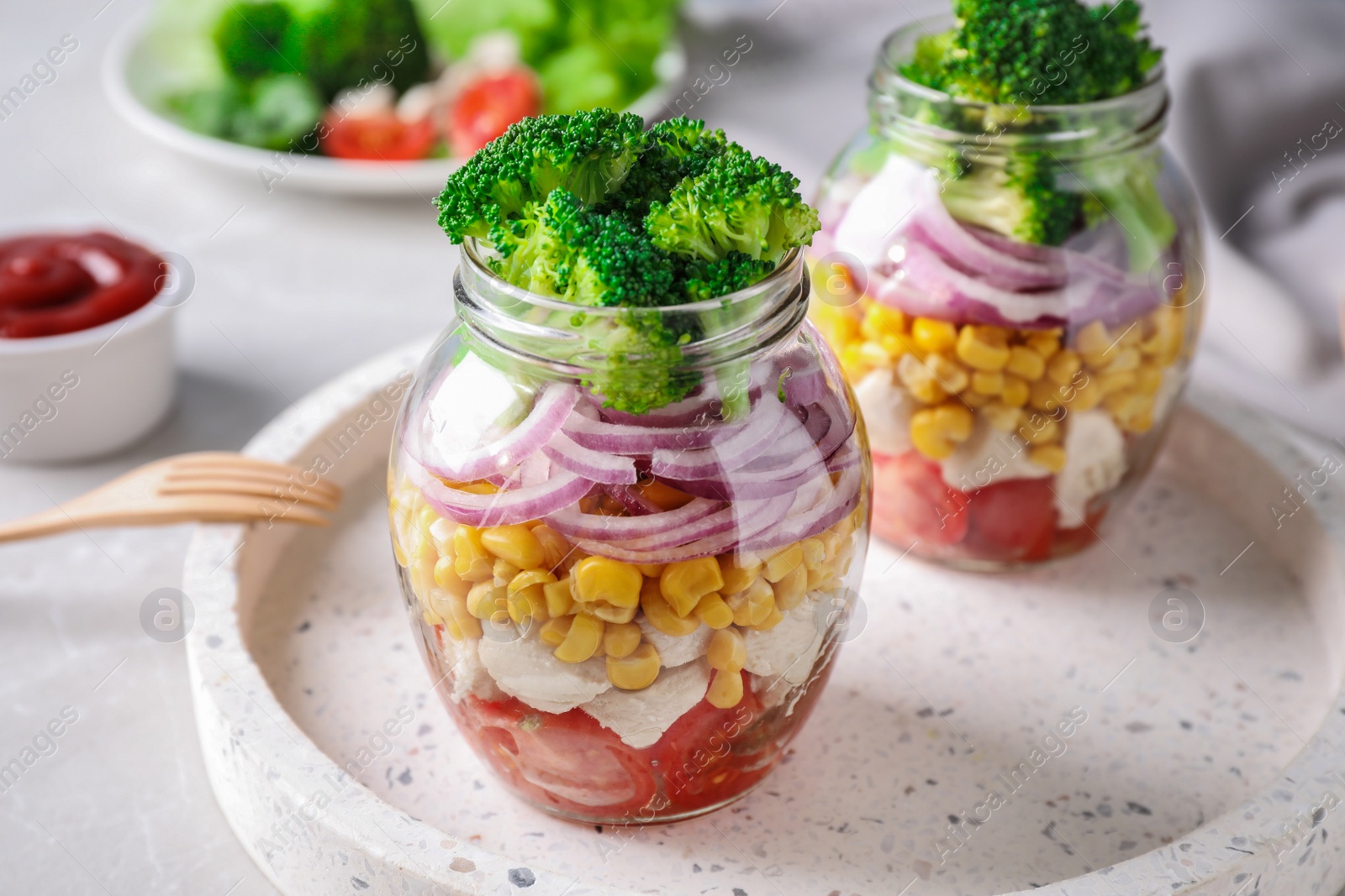 Photo of Healthy salad in glass jars on light table