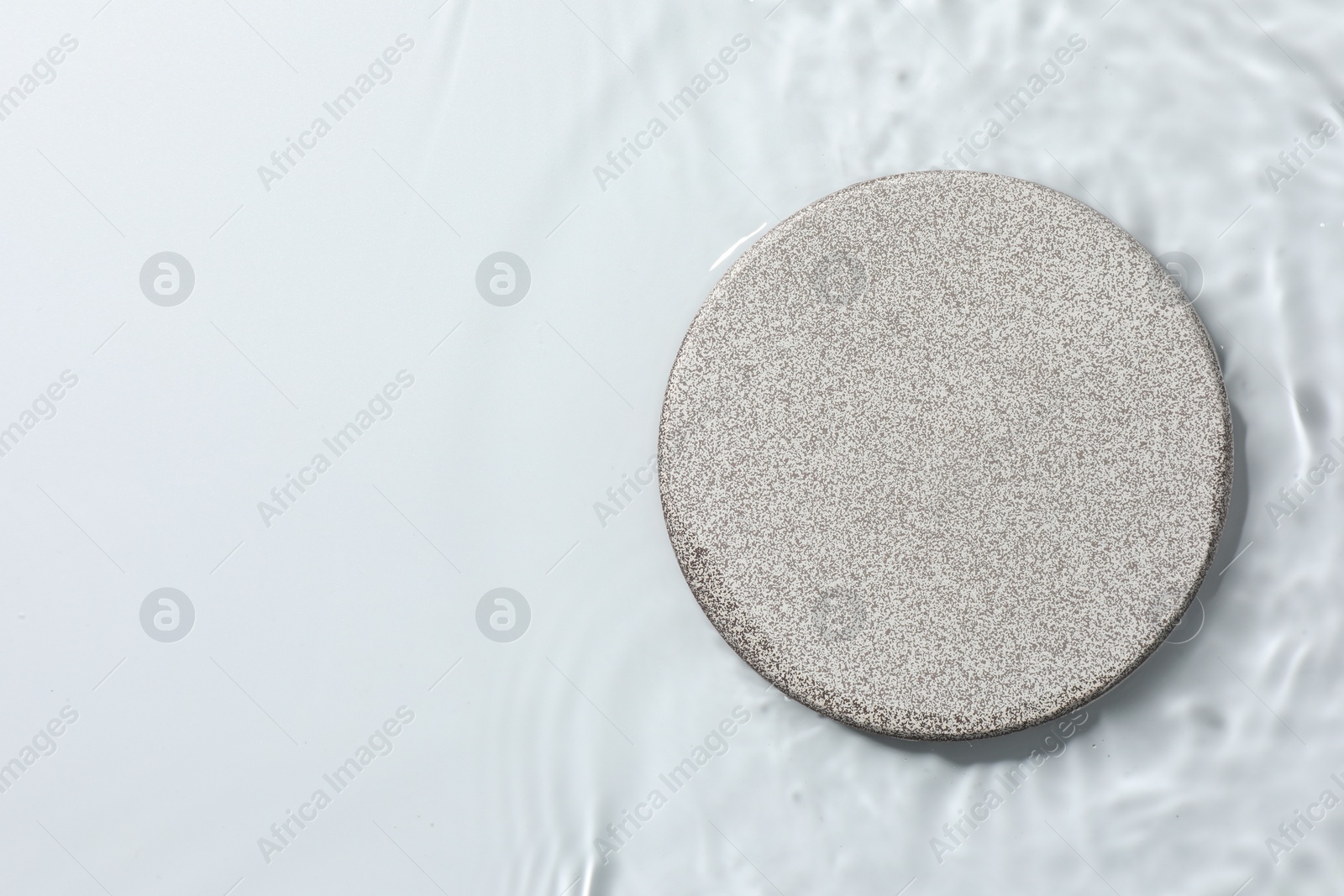 Photo of Presentation of product. Stone podium in water on white background, top view. Space for text