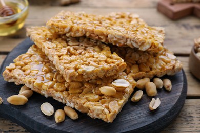 Photo of Delicious peanut kozinaki bars on wooden table, closeup