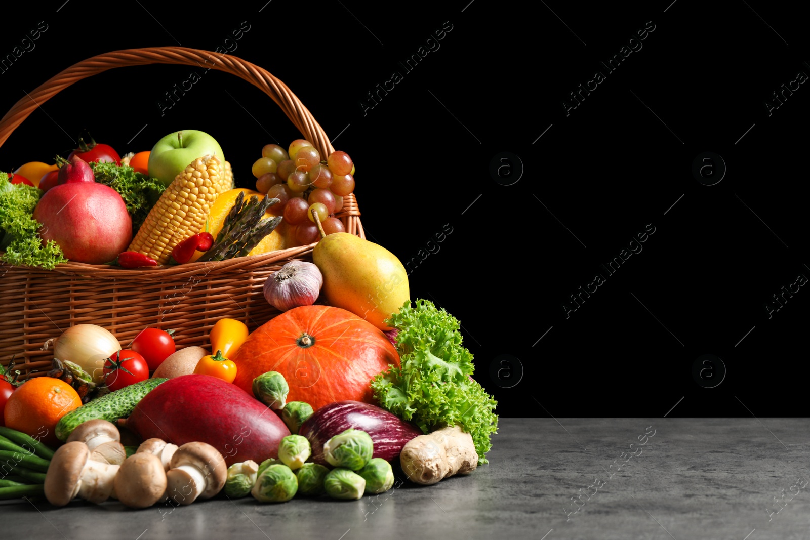 Photo of Assortment of fresh organic fruits and vegetables on grey table. Space for text