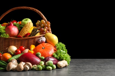 Photo of Assortmentfresh organic fruits and vegetables on grey table. Space for text