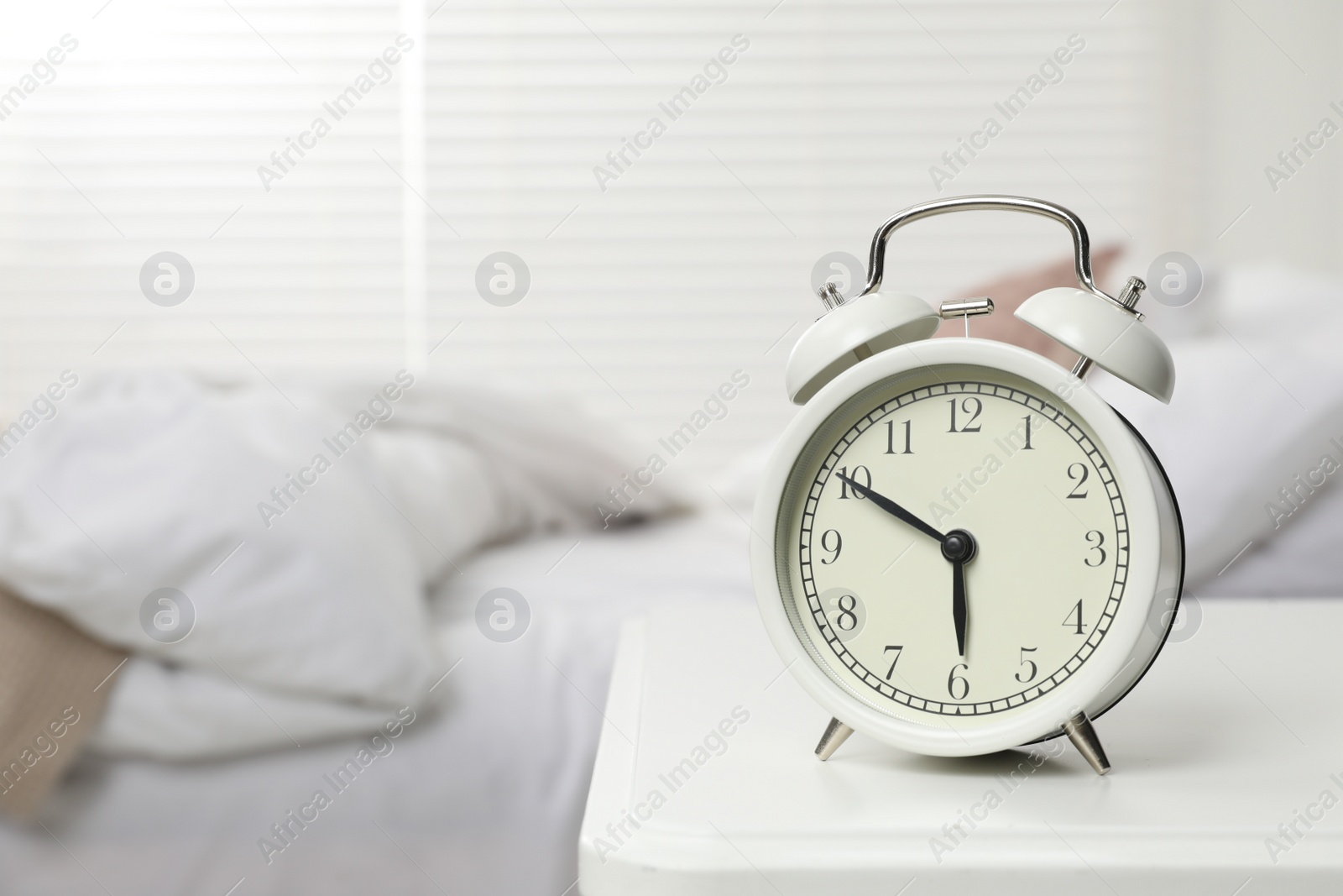 Photo of Alarm clock on white nightstand in bedroom, space for text