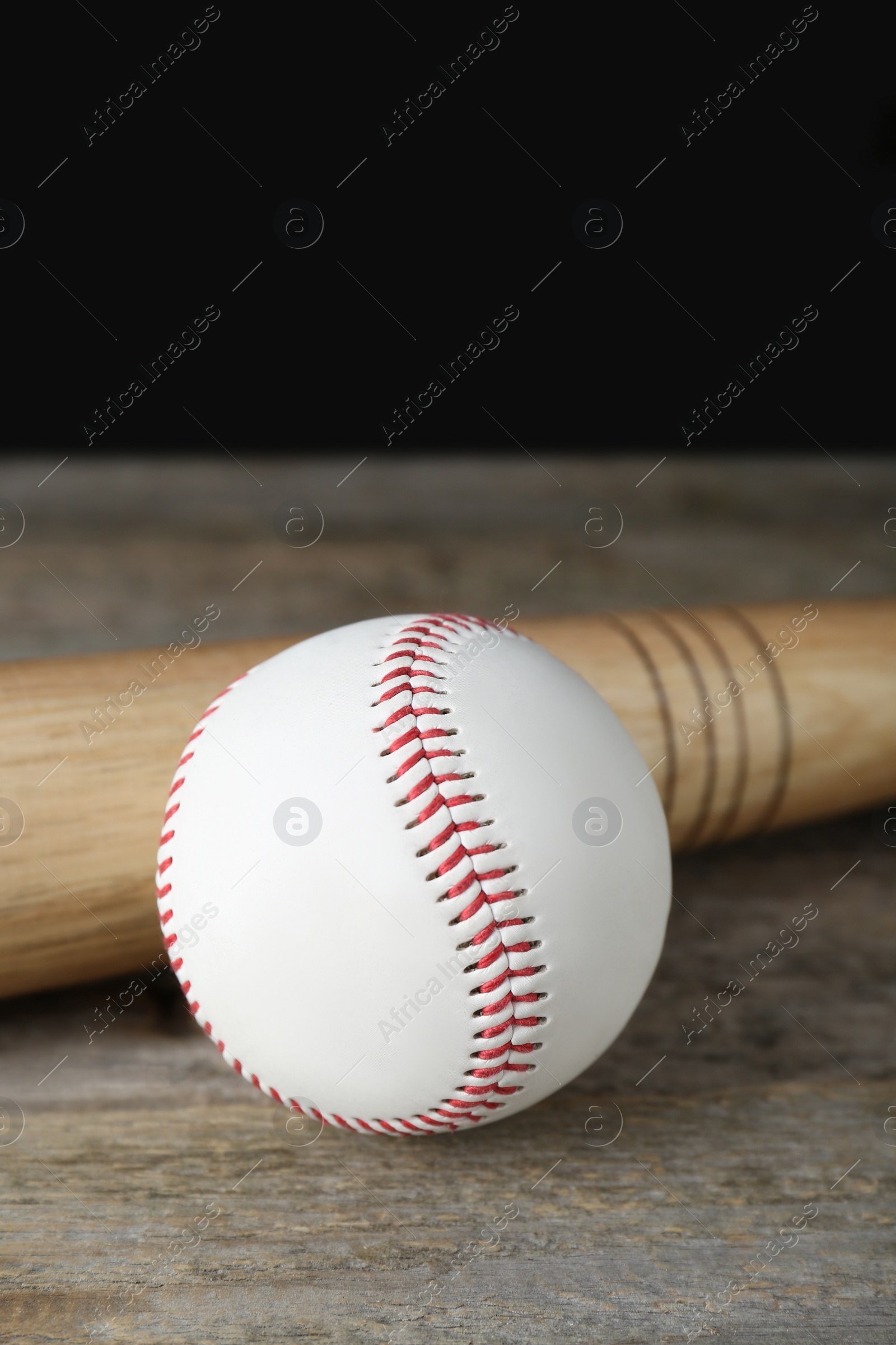 Photo of Baseball ball and bat on wooden table. Sports equipment