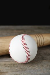 Photo of Baseball ball and bat on wooden table. Sports equipment