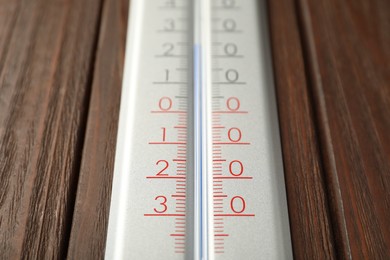 Photo of Modern weather thermometer on wooden background, closeup