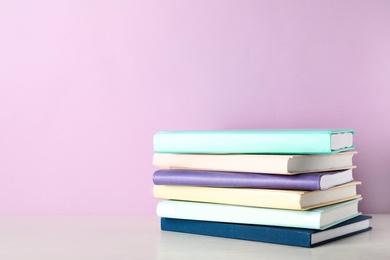 Photo of Stack of books on shelf against color background. Space for text