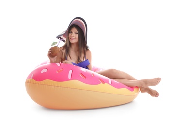 Photo of Sexy young woman in bikini with inflatable ring and coconut cocktail on white background