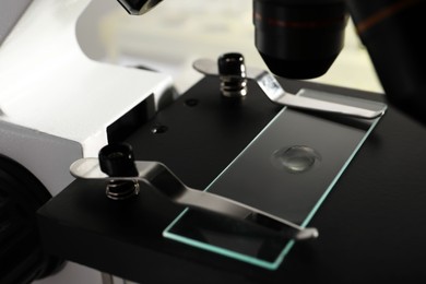 Photo of Microscope with drop of urine on glass slide, closeup