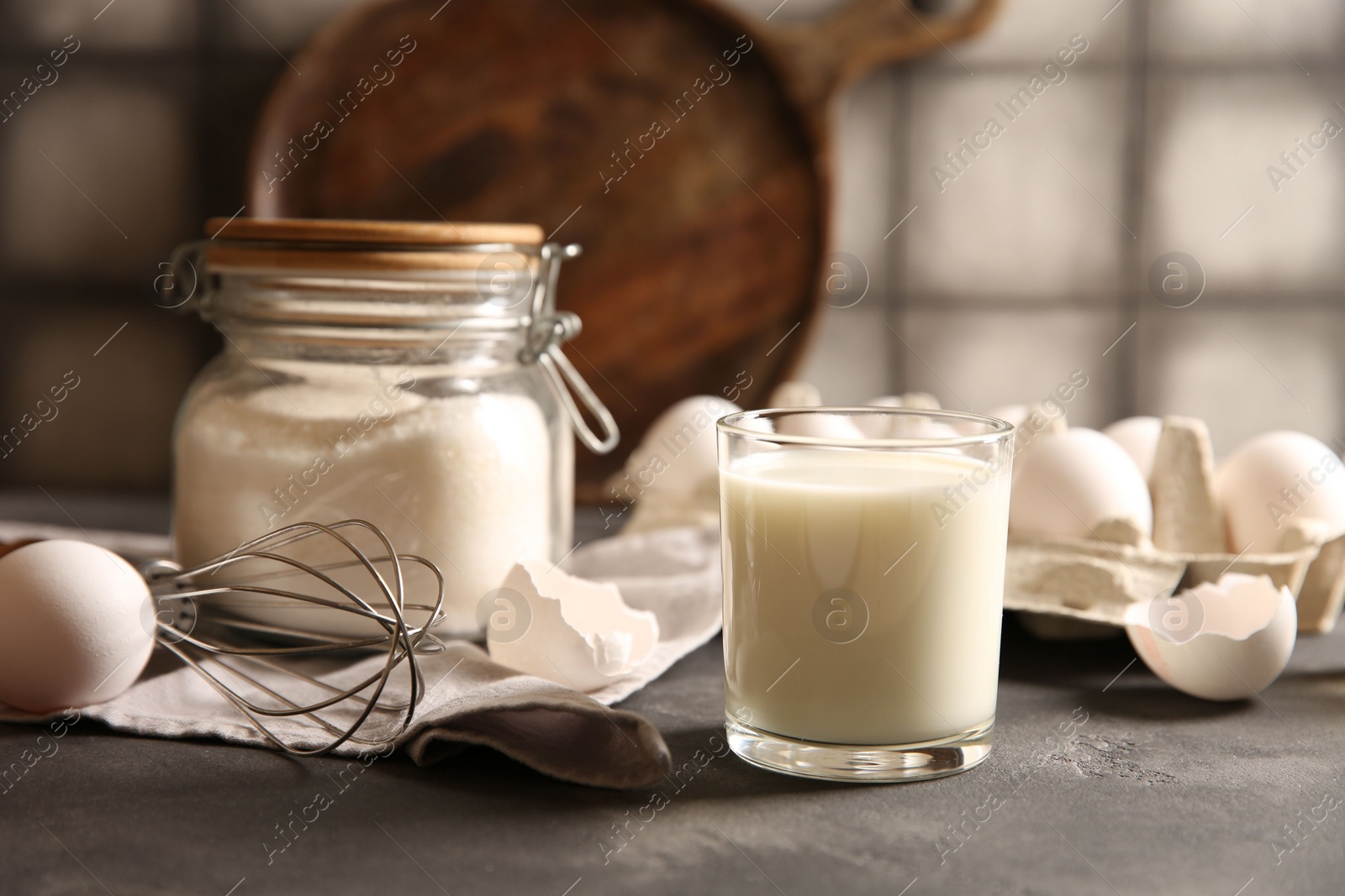 Photo of Different ingredients for dough on grey table, closeup