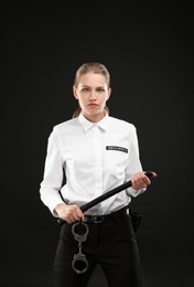 Photo of Female security guard with police baton on dark background