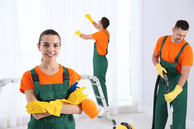 Team of professional janitors cleaning room after renovation