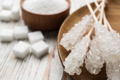 Photo of Different types of sugar on white wooden table, closeup