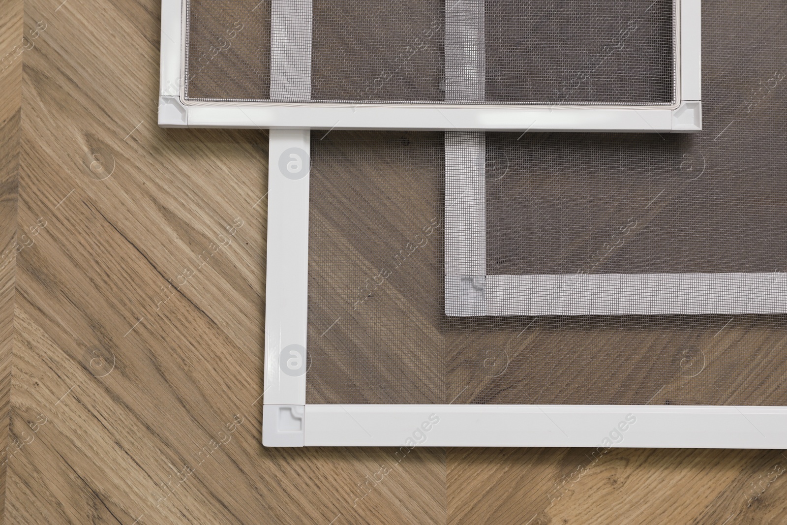Photo of Set of window screens on wooden floor, flat lay
