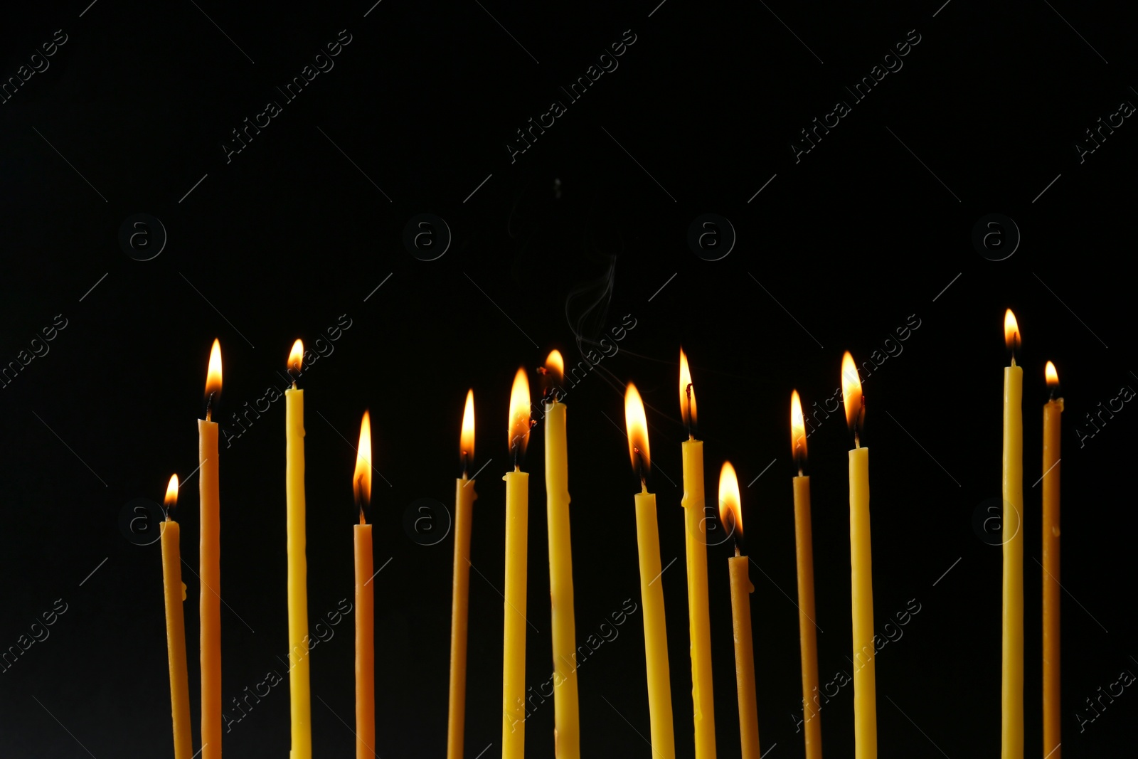 Photo of Burning candles on black background. Symbol of sorrow