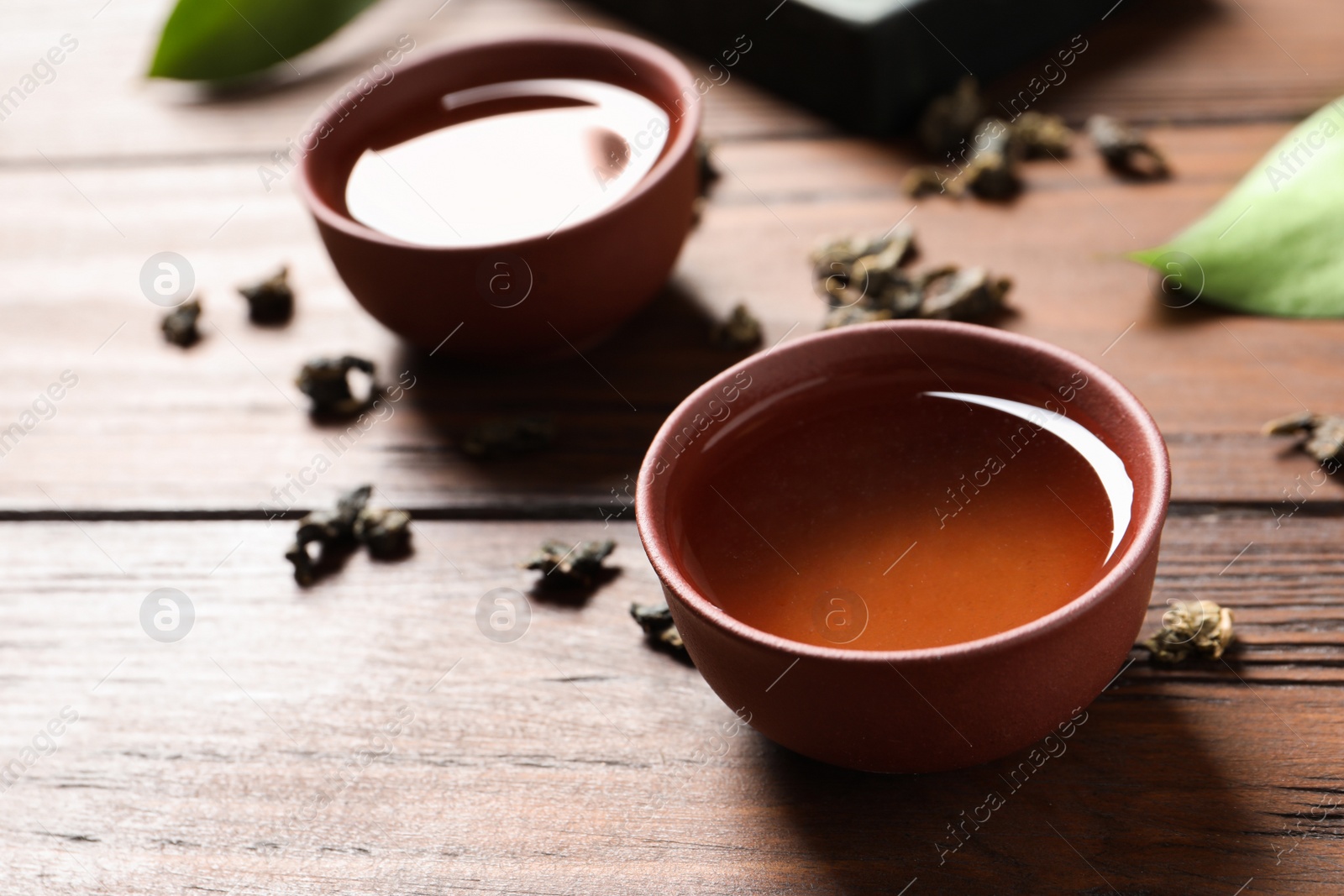 Photo of Cup of Tie Guan Yin oolong tea on wooden table. Space for text