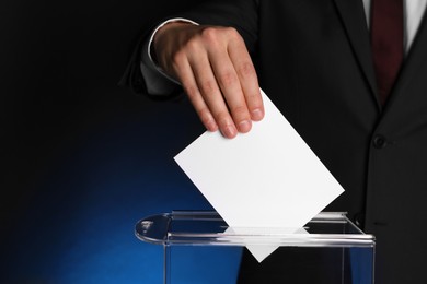 Photo of Man putting his vote into ballot box on dark blue background, closeup. Space for text