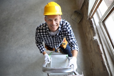 Photo of Professional constructor on ladder in old building, above view