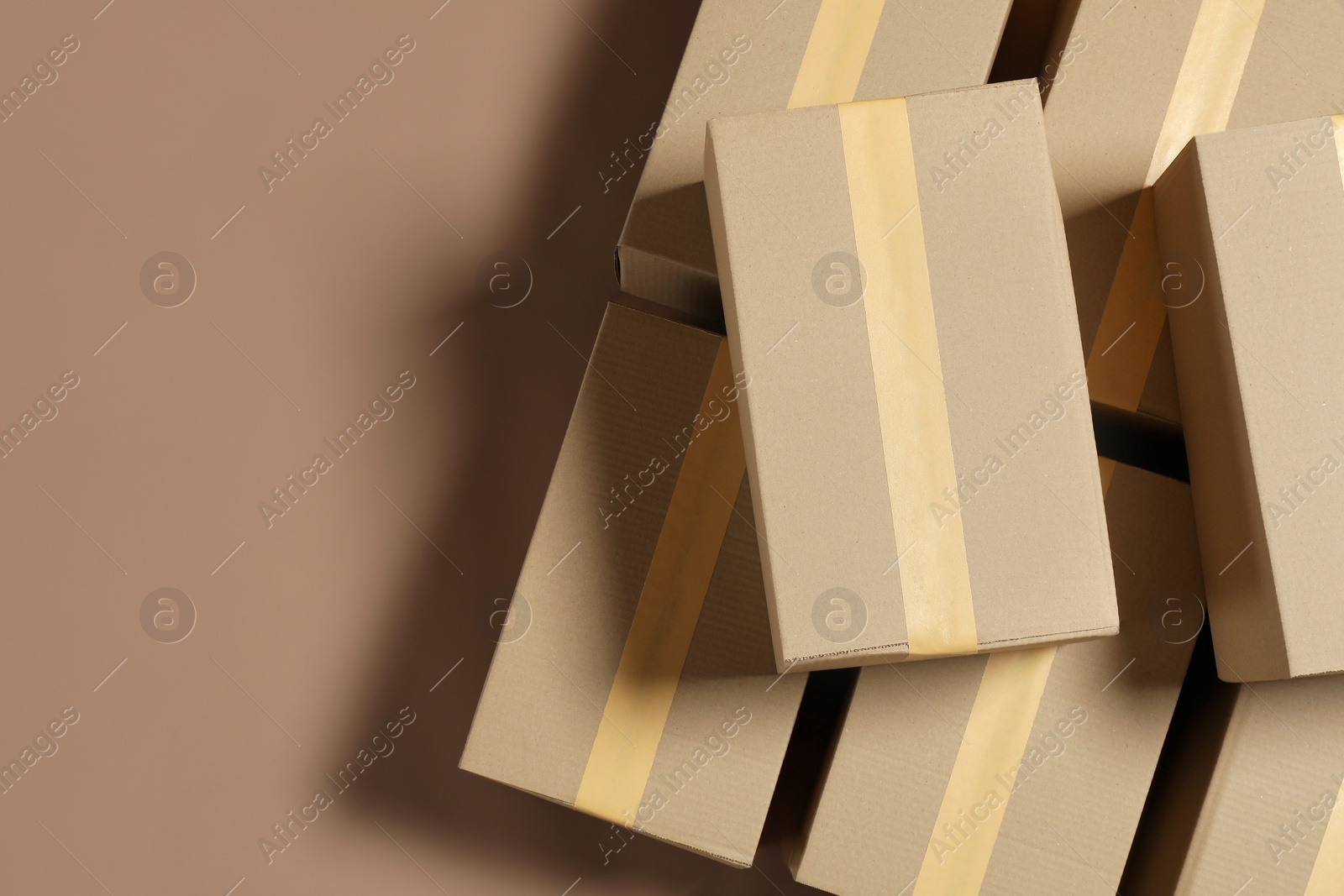 Photo of Many cardboard boxes on light brown background, flat lay. Space for text